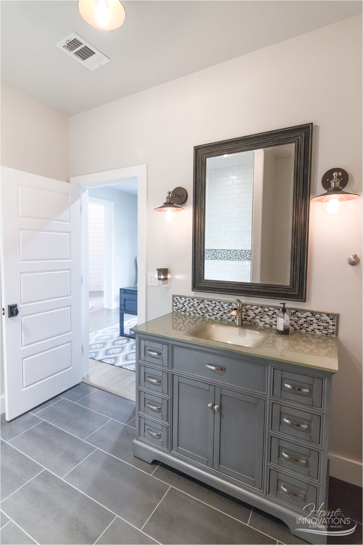 custom home builder tulsa ok bathroom with gray porcelain tile floor gray cabinets brushed nickel faucets oil rubbed bronze hanging sconces