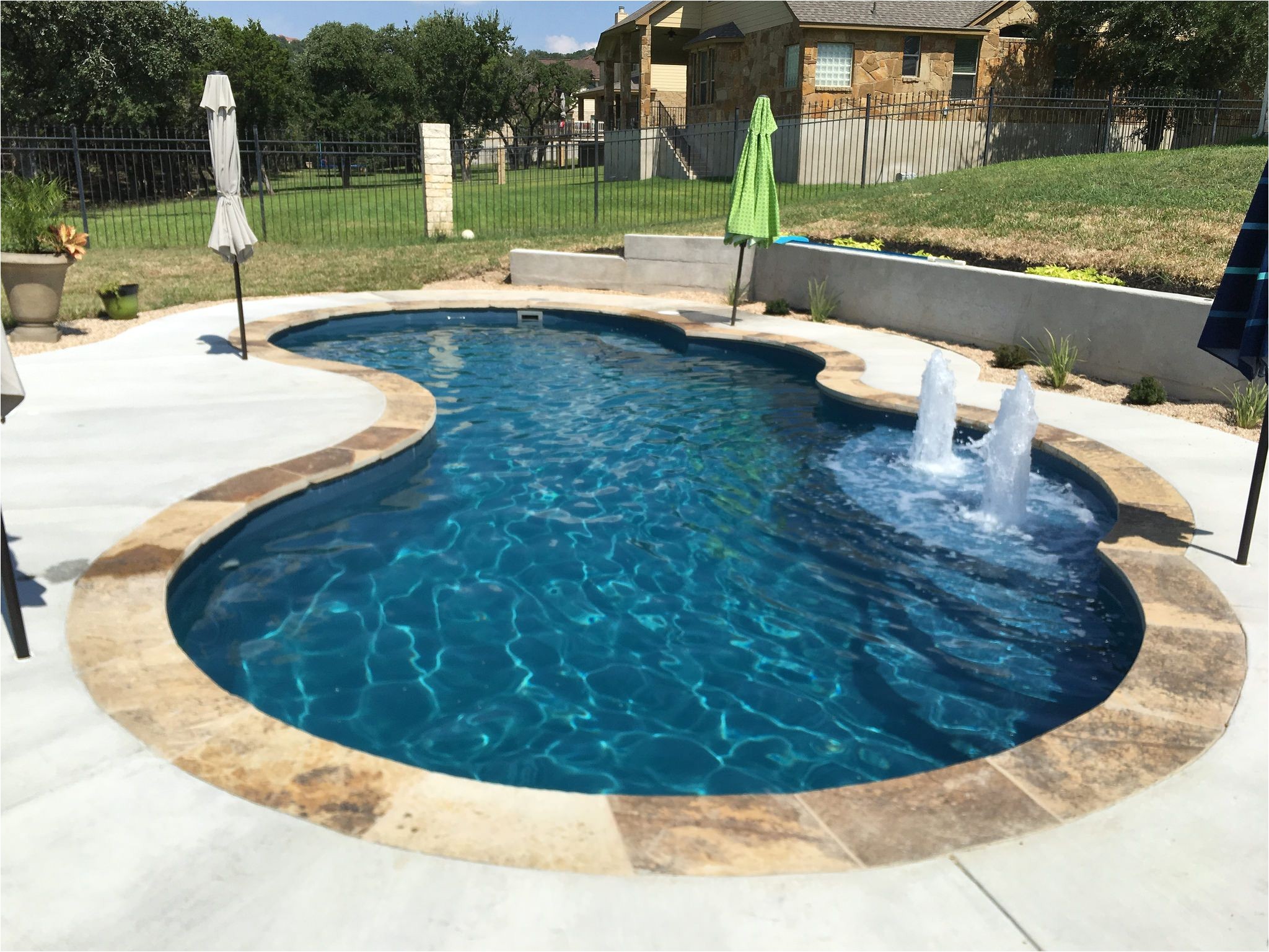 this 16 x 32 gemini shaped fiberglass inground pool complete in vega color sandstone coping and bubblers is perfect for your backyard upgrade