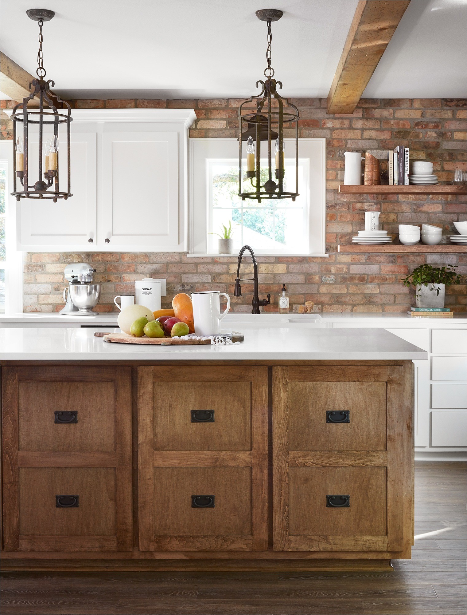 the client really wanted an antique brick backsplash so we carried it from countertops to ceiling to make a bold statement we kept the rest simple with