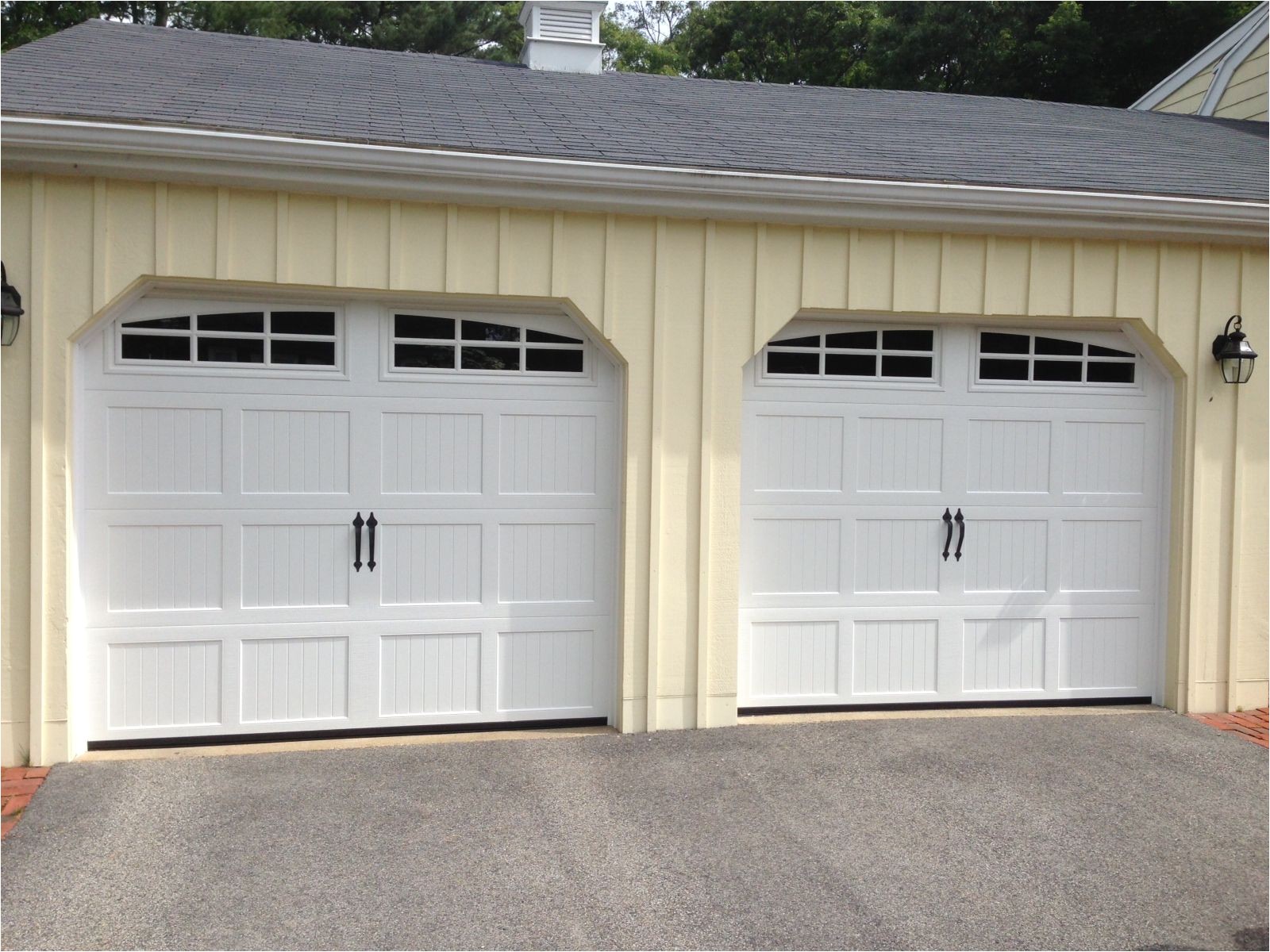 haas model 660 steel carriage house style garage doors in white with arch 6 pane glass flat black spade handles installed by mortland overhead door