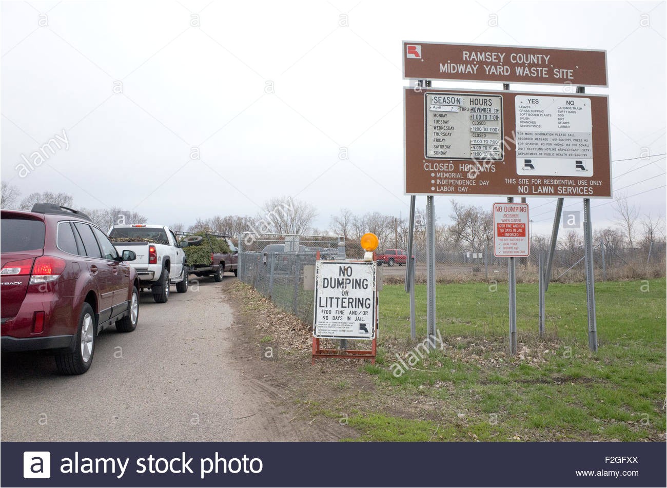 cars at entrance to ramsey county midway yard waste site with leaves and branches for recycling st paul minnesota mn usa