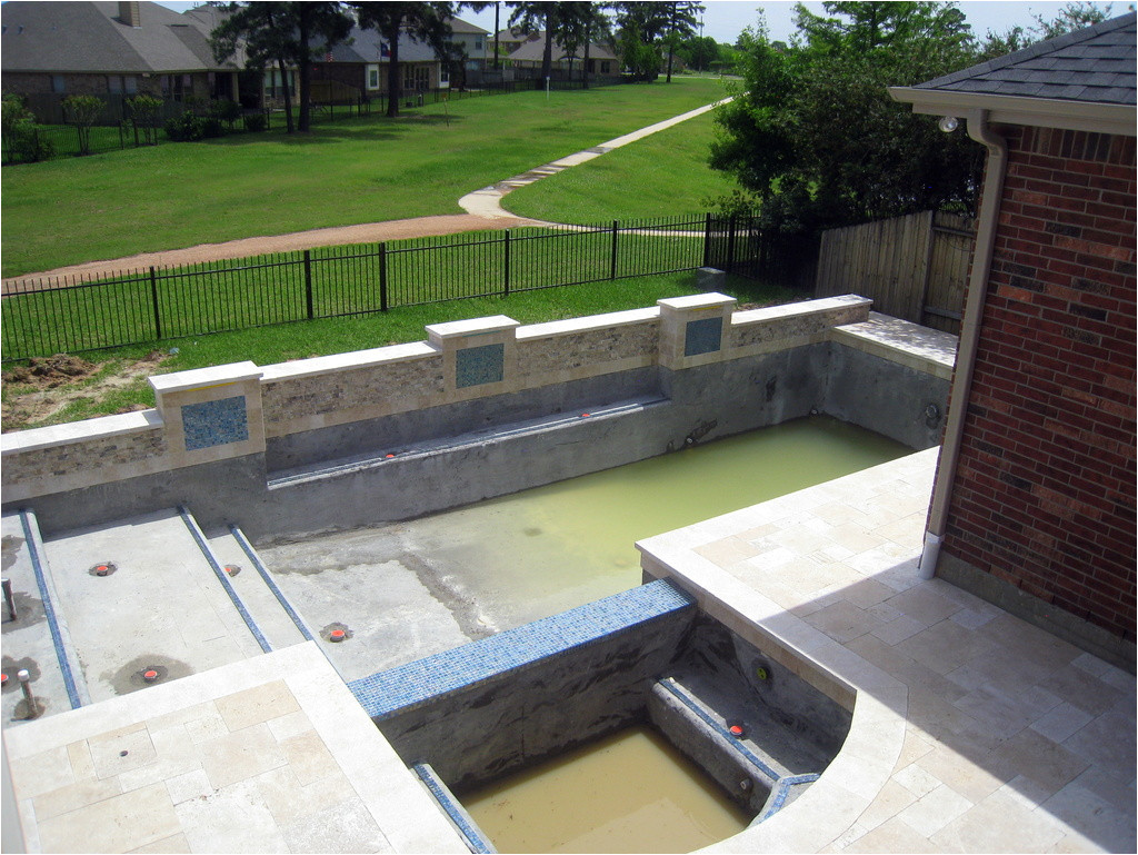 patio cover and travertine deck are done trim tile is installed waiting for pebble sheen