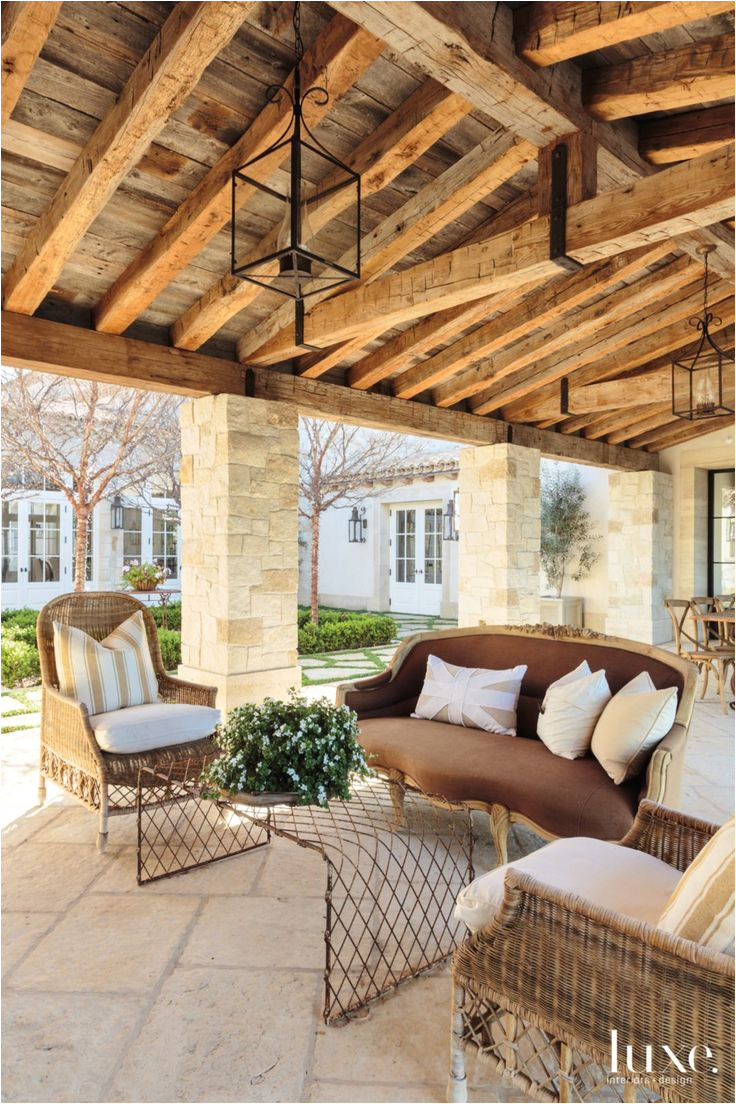 a cozy seating arrangement overlooks the courtyard with pavers from orange county stone lining its perimeter rattan chairs and an unusual wire grid coffee