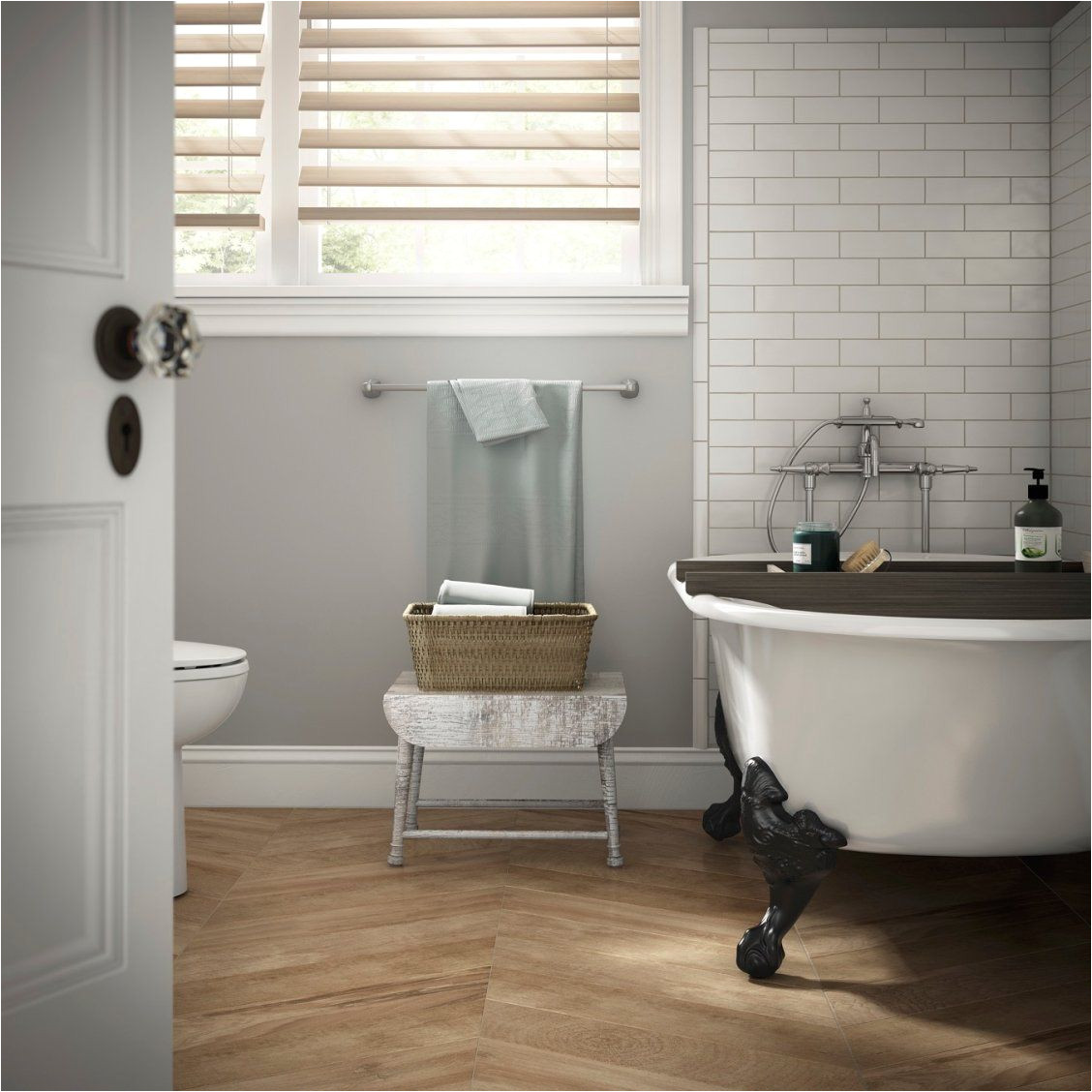 create a spa like bathroom with soft gray walls a clawfoot tub striking herringbone floors and classic white subway tiles around the tub