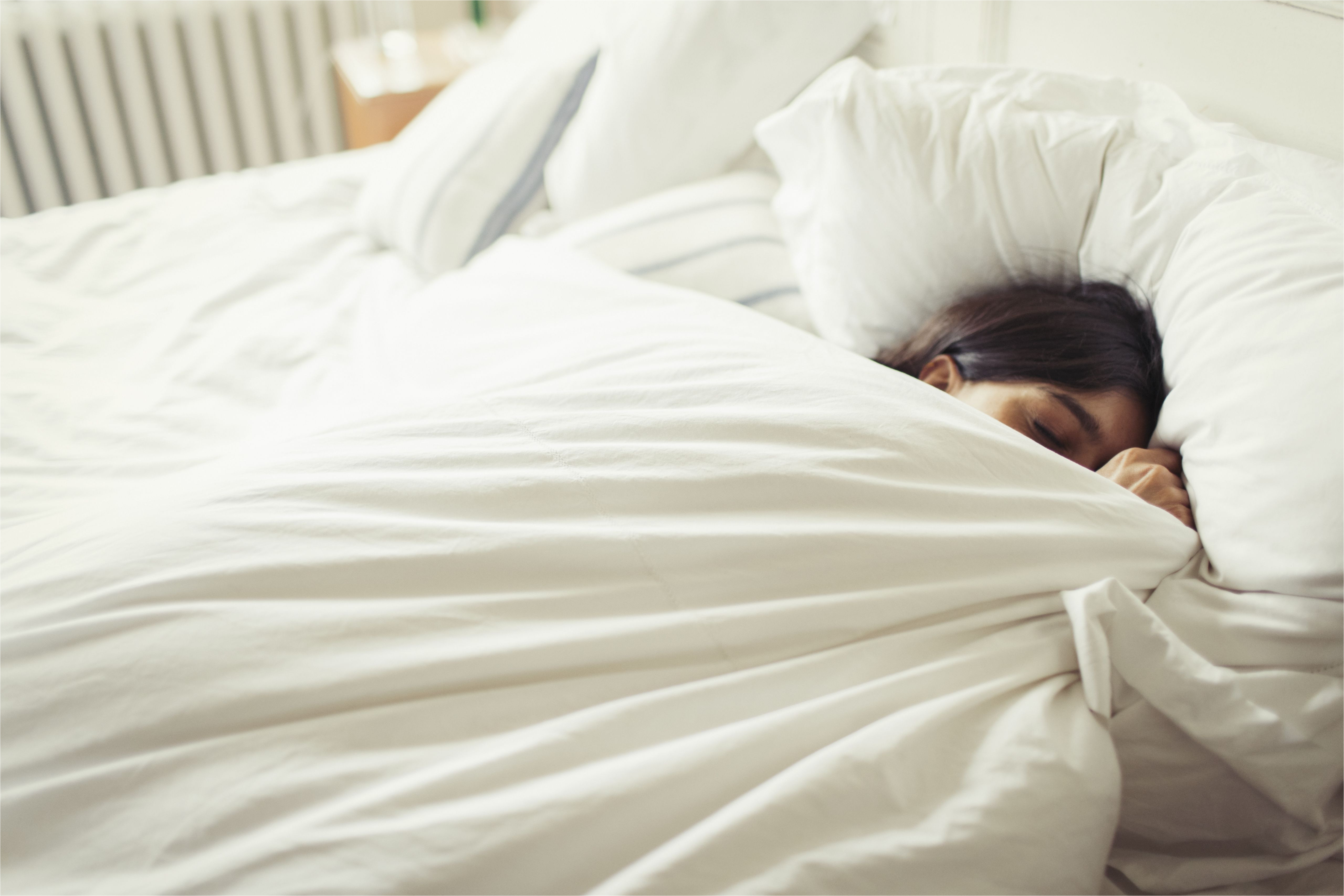 tired young woman sleeping in bed 922710678 5b1ee4faff1b780037b43d34 jpg