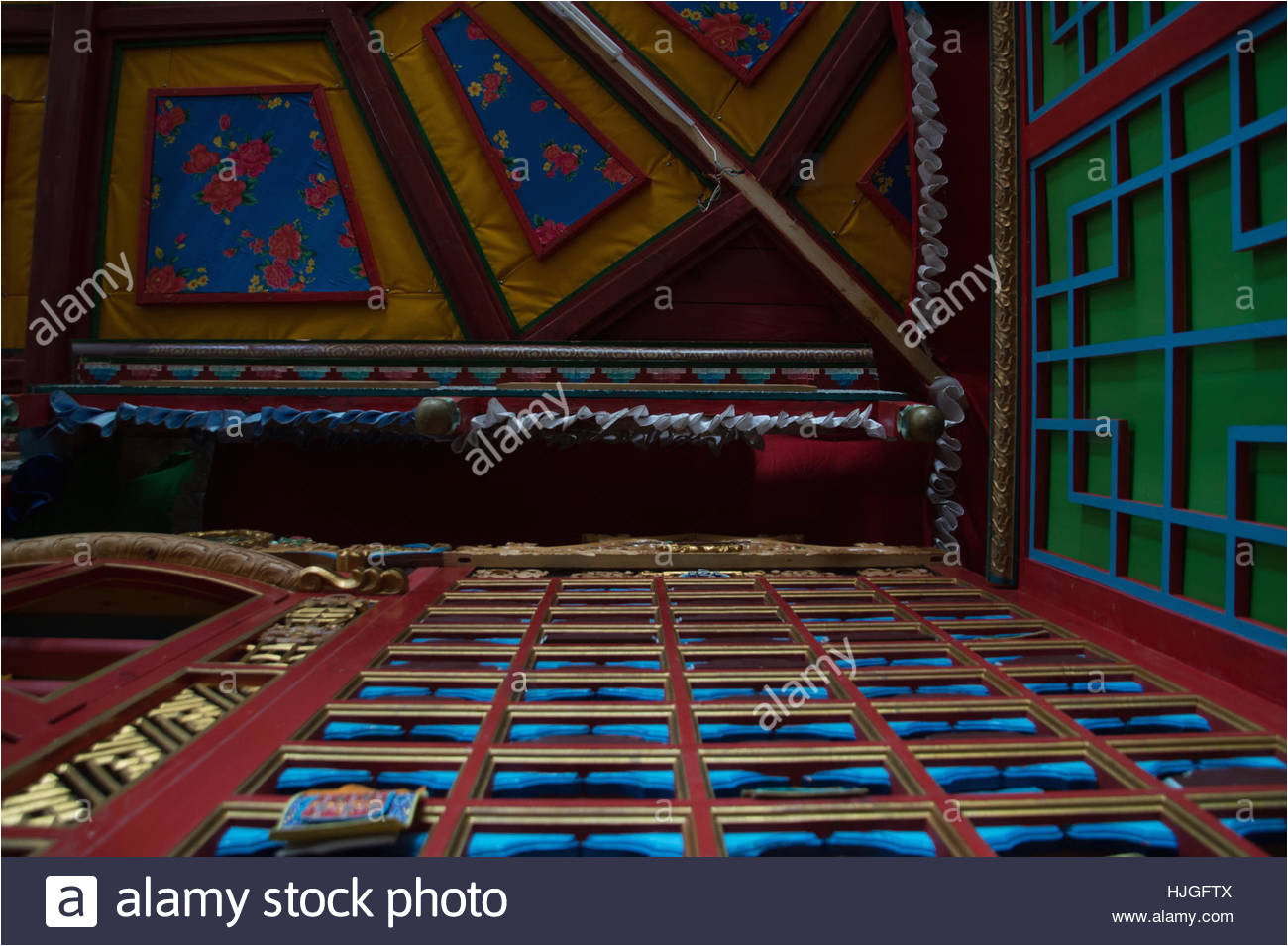 close up of hand painted wooden bins from below that store cloth scrolls and fabric covered