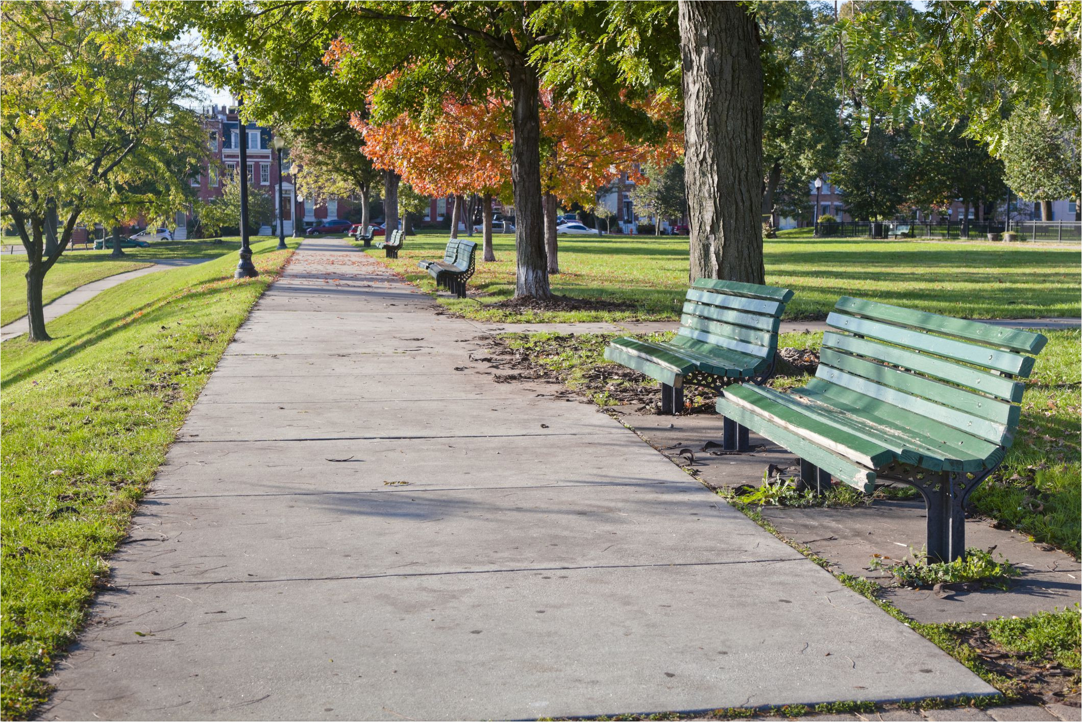 green wooden benches lined up along a sidewak on a sunny autumn day baltimore s federal hill