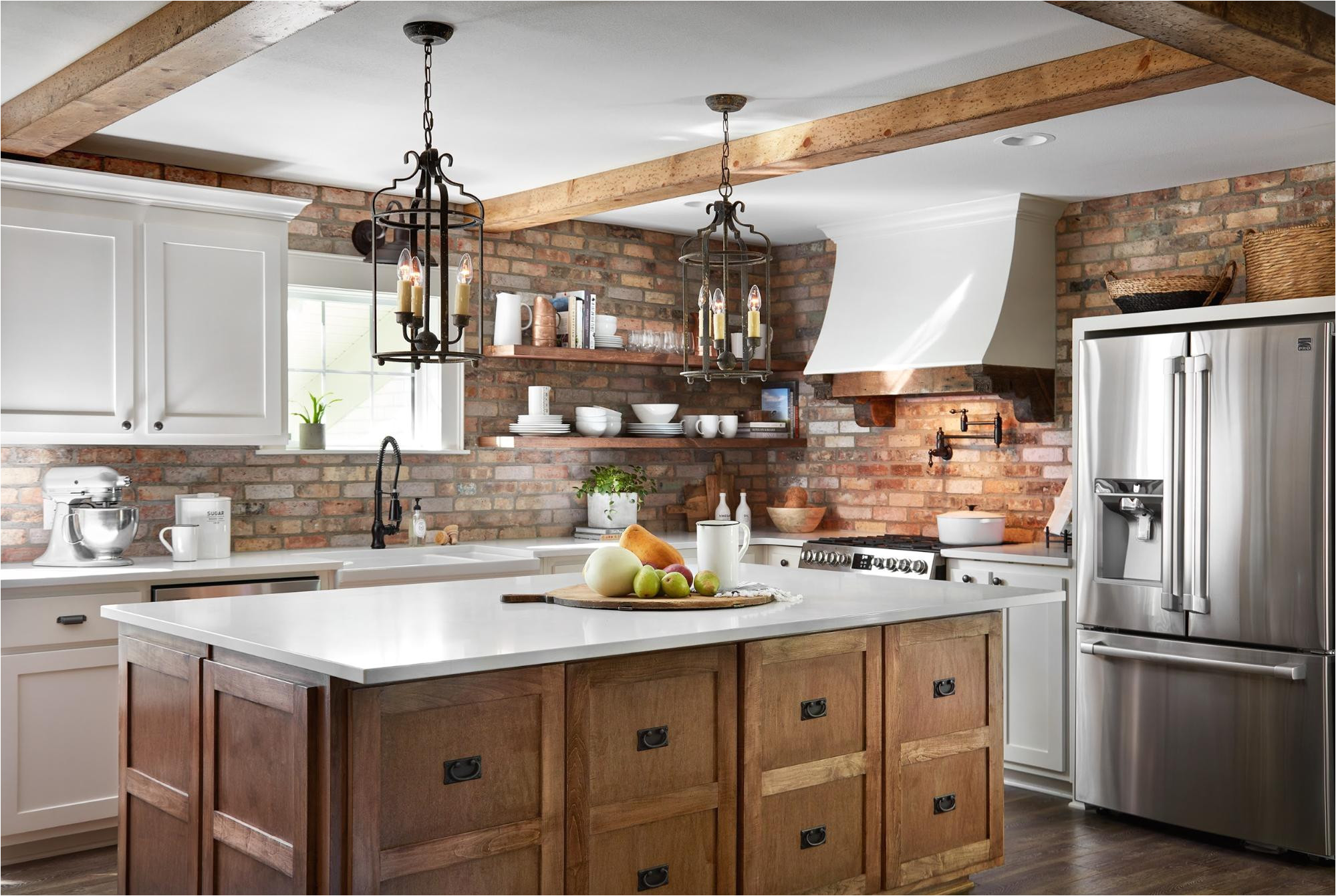 too much upper cabinetry could ve felt heavy and overpowering with the additional texture of the brick so we decided to outfit this oversized island and