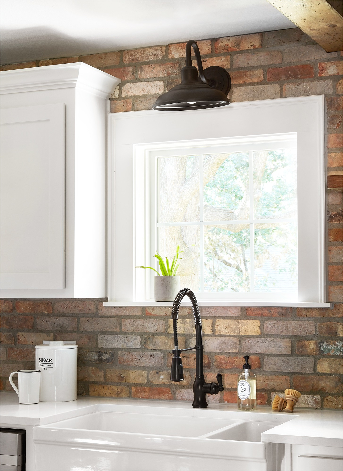 the client really wanted an antique brick backsplash so we carried it from countertops to ceiling to make a bold statement we kept the rest simple with