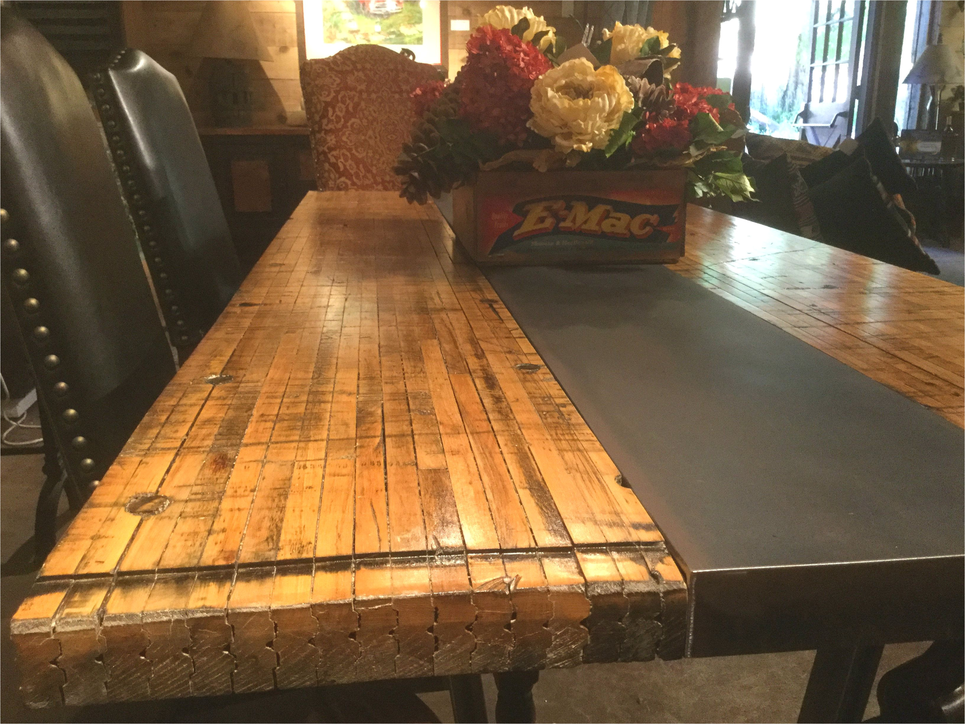 this unique table top is made out of the flooring from train boxcars and is supported by a steel center
