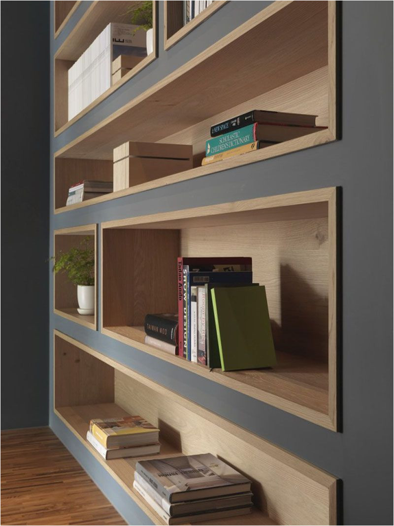 to make the built in bookshelves on this deep grey wall stand out the shelves were lined with wood to add a natural touch and create warmth in the office