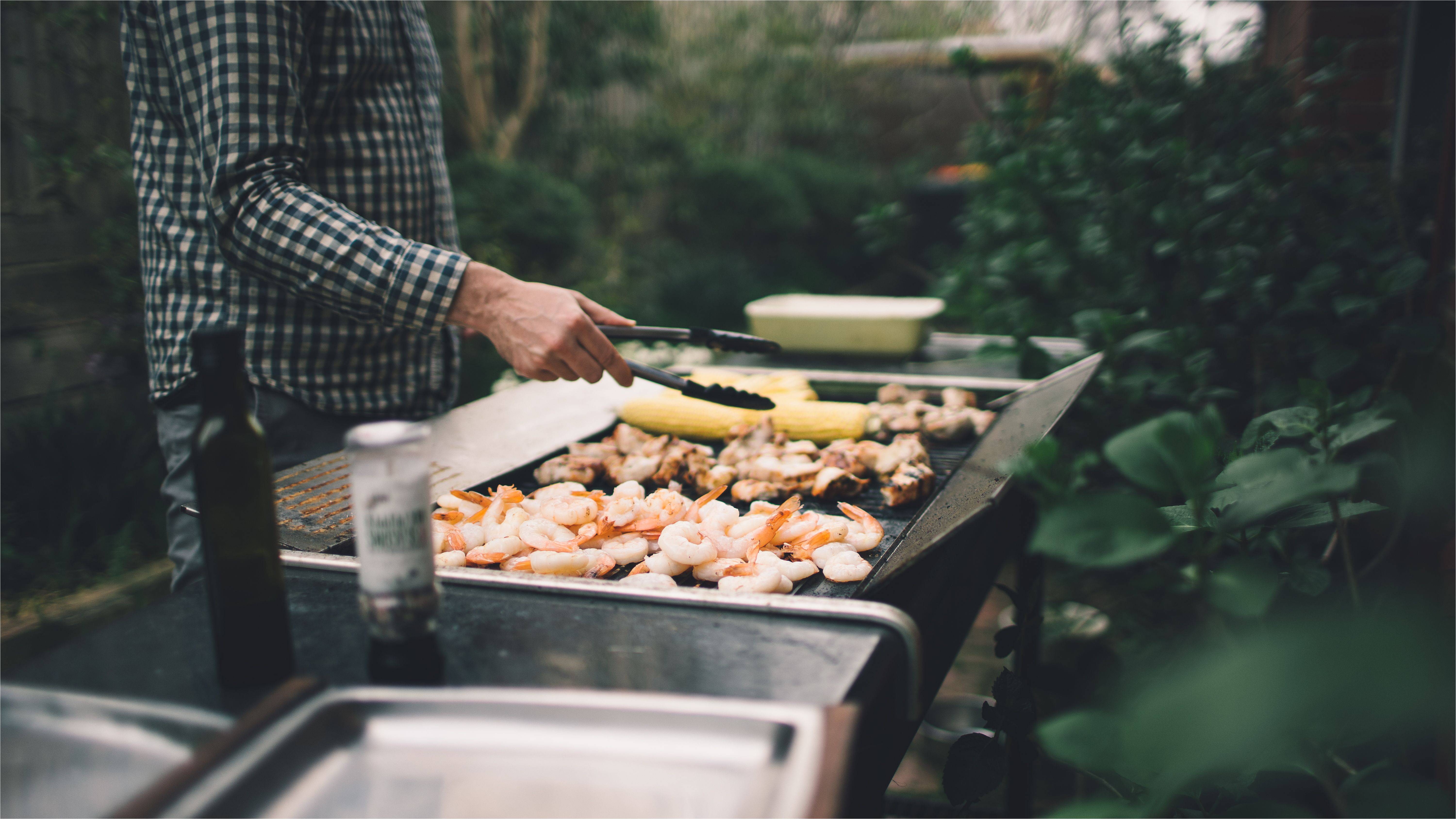 holding tongs grilling prawns meat and vegetables on barbecue 615752168 5a724570ba61770037c28d46 jpg