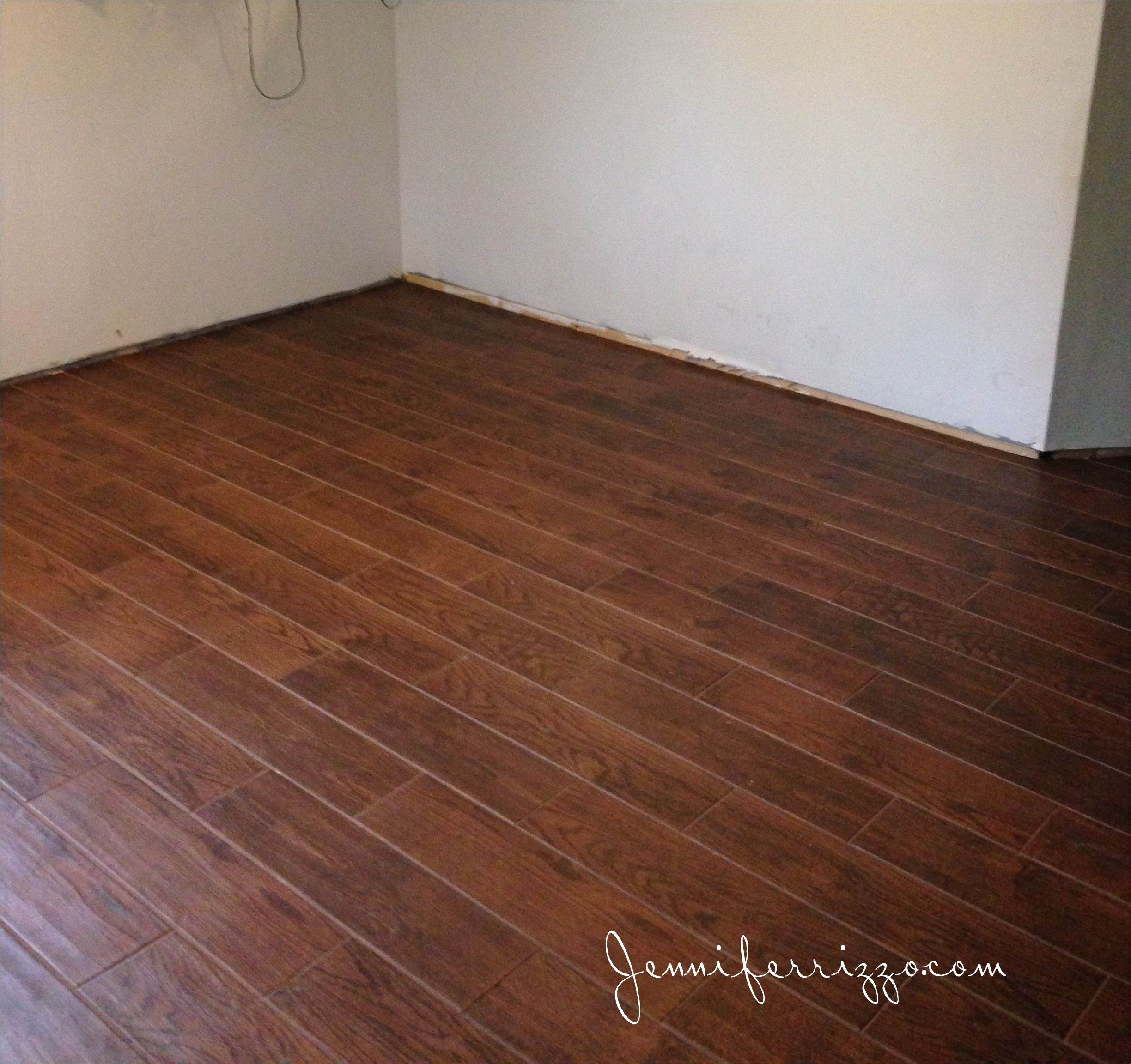 installation of our wood look ceramic tile from home depot in our basement living room and white ceramic mosaic tile with gray grout in our laundry room