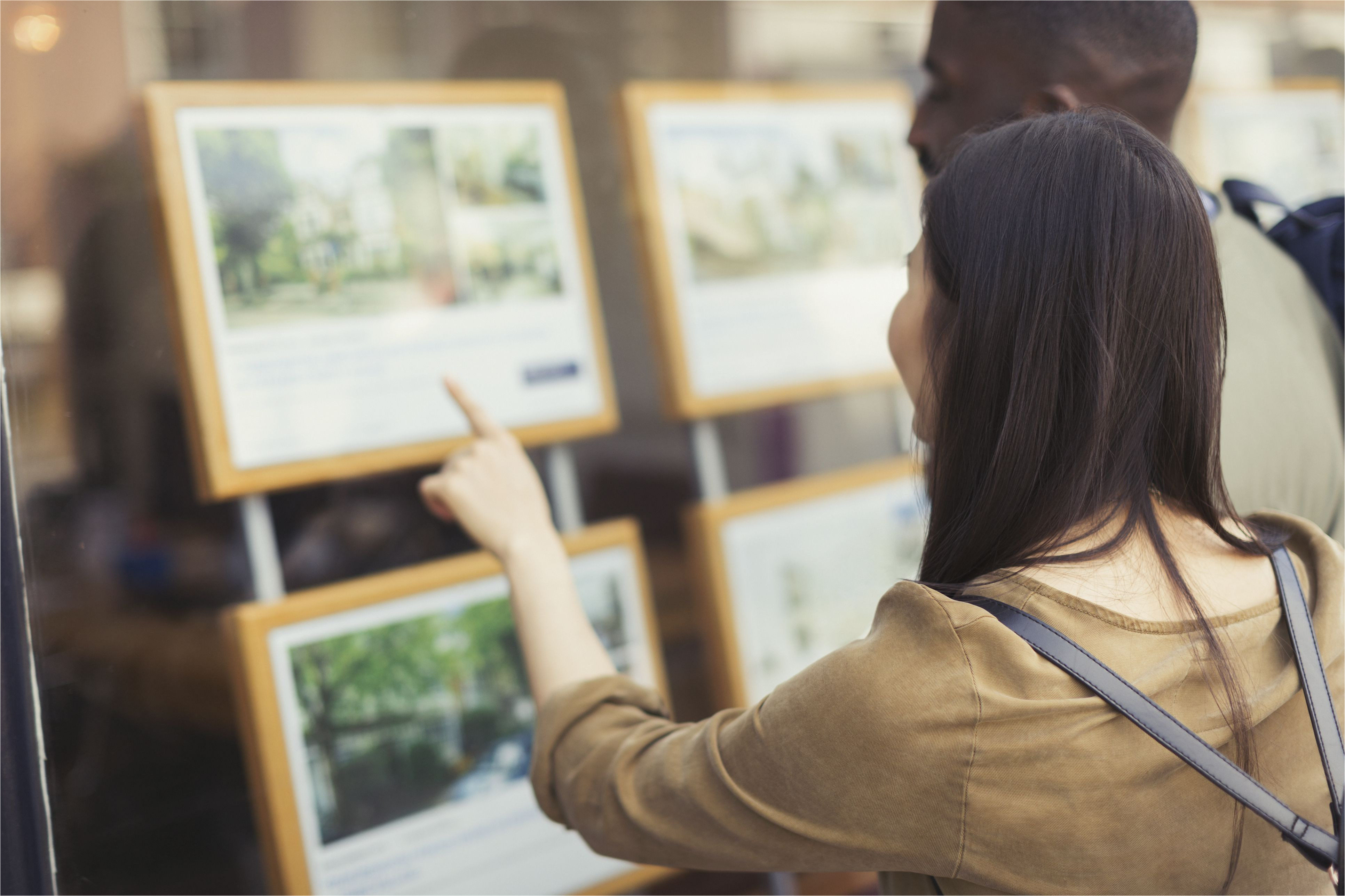 young couple browsing real estate listings at storefront 906503752 5a9e16593de423003731405a jpg