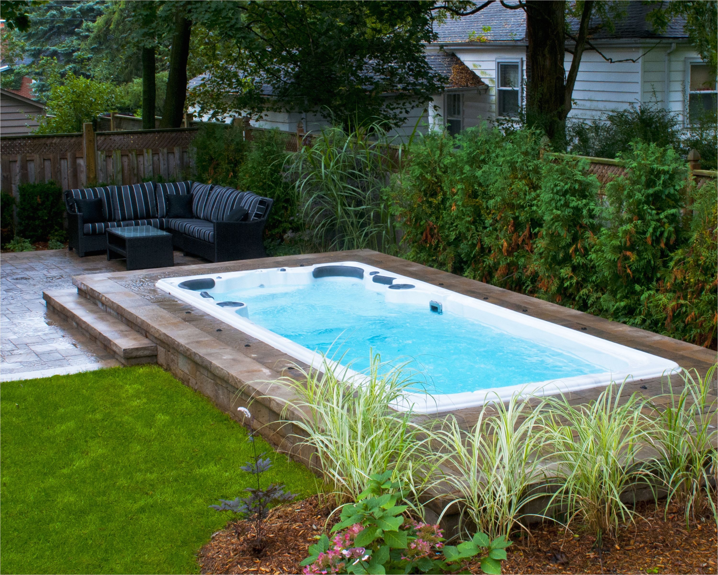 hydropool self cleaning swim spa installed in ground with stone deck learn more about hydropool