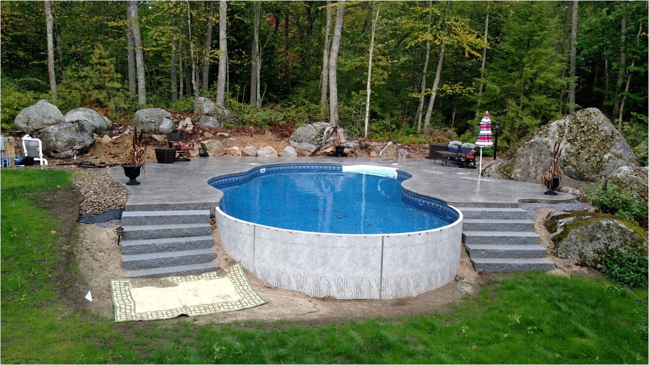 radiant 18x32 freeform built into a hill with stamped concrete deck and walk in steps