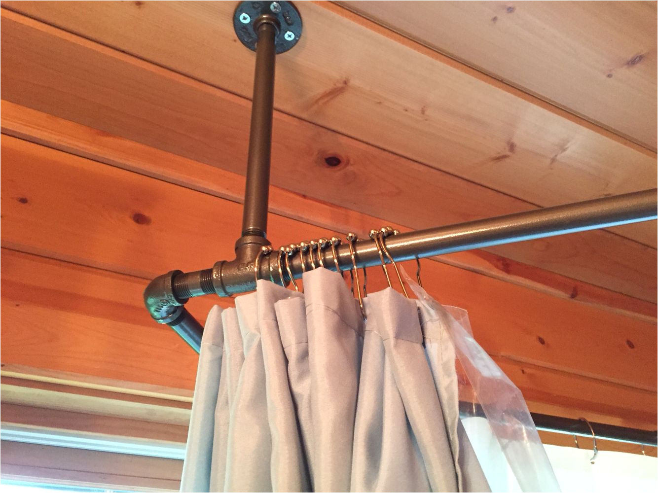 used black iron piping to create a shower curtain rod that surrounds our corner jetted tub