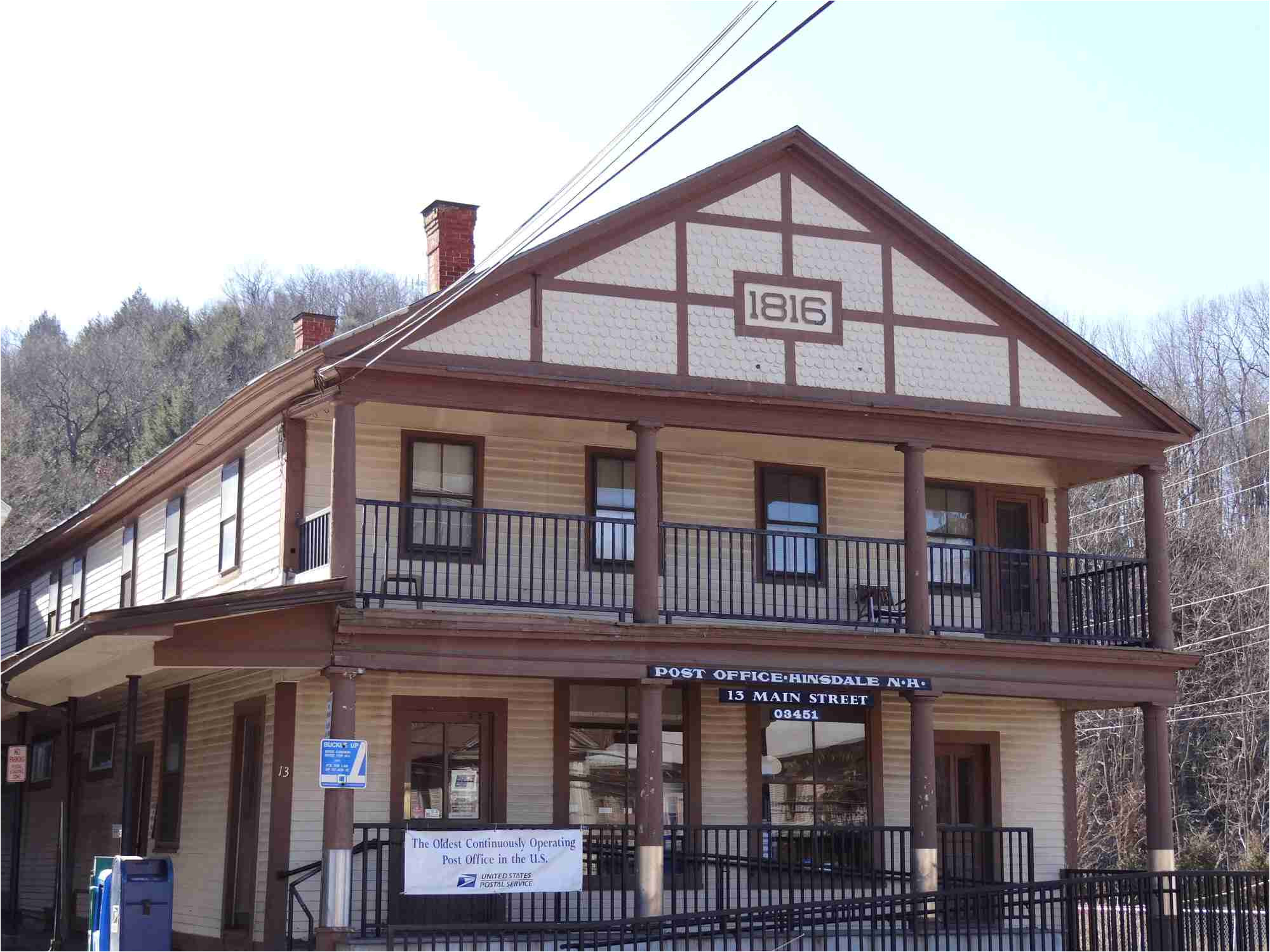 photo of two story tan building dark brown trim front porches on both floors