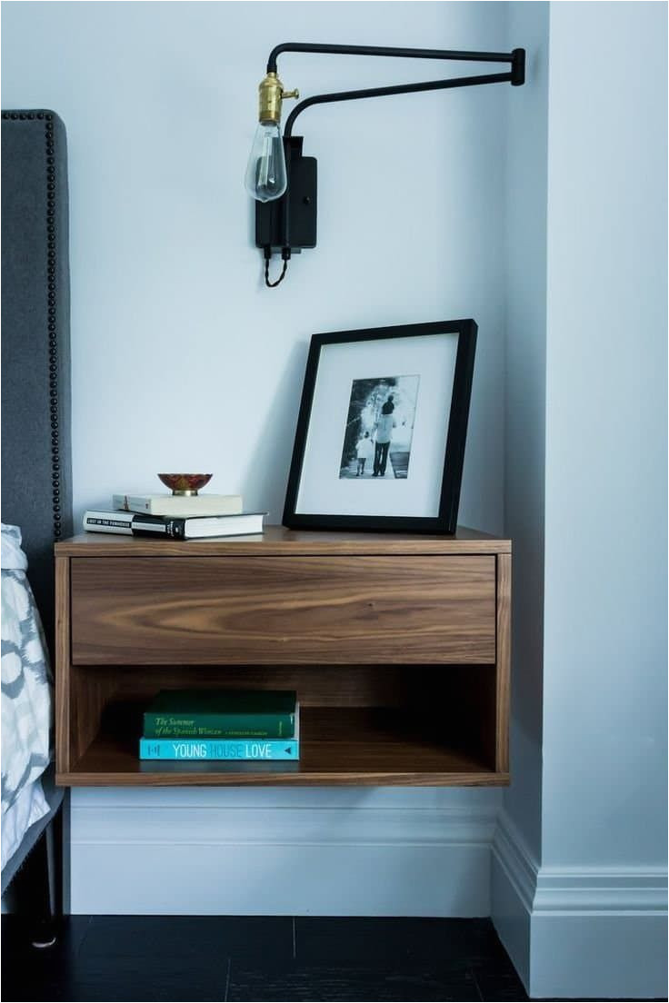floating modern wood nightstand with swing arm sconce and photo frame