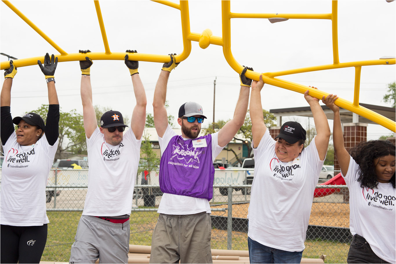volunteers lift up playground equipment for installation south houston elementary playground