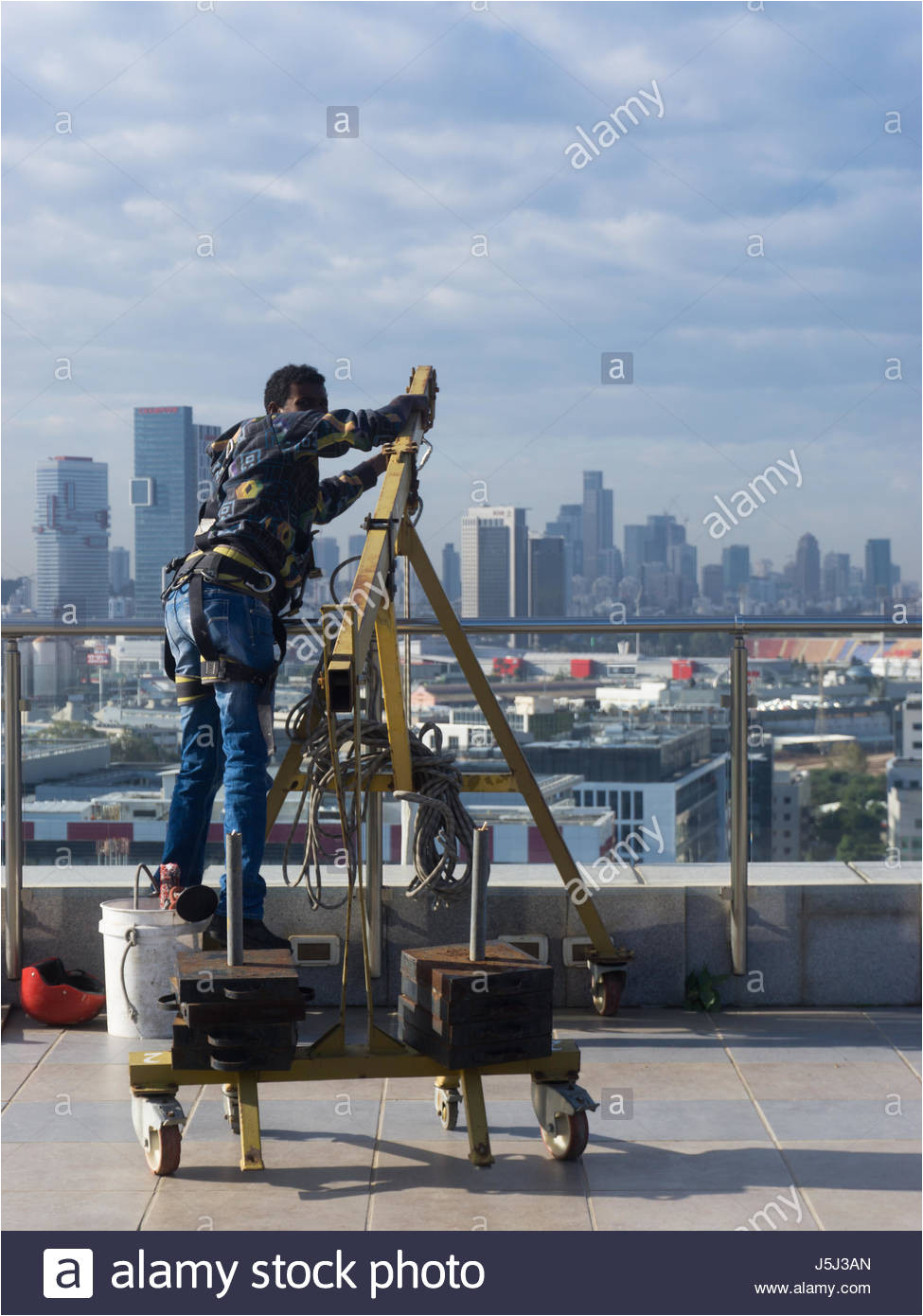 window cleaning employee with work tools and city background stock image