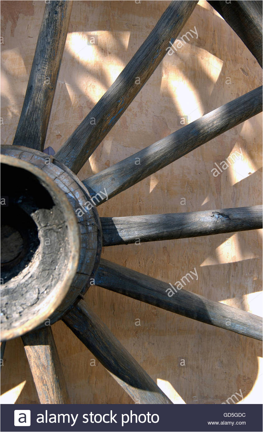 cart wheel against old wall stock image