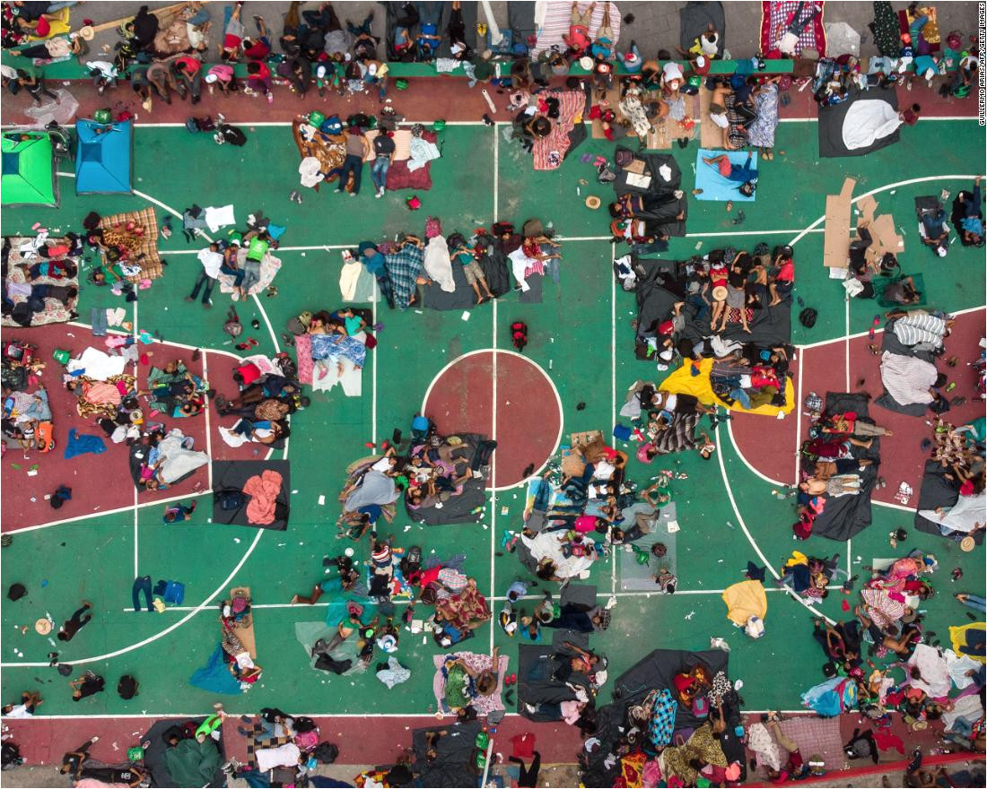 migrants heading in a caravan to the united states rest on a basketball court in san