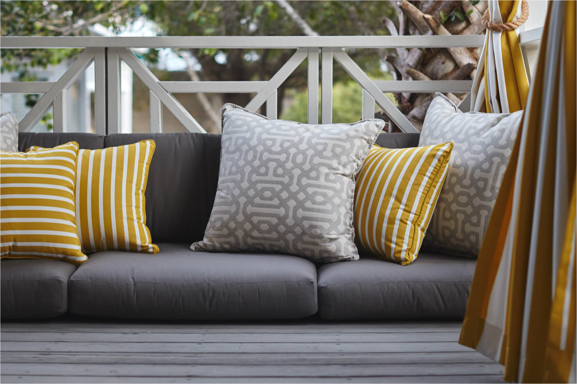 grey outdoor cushions with yellow and grey decorative pillows and yellow drapery