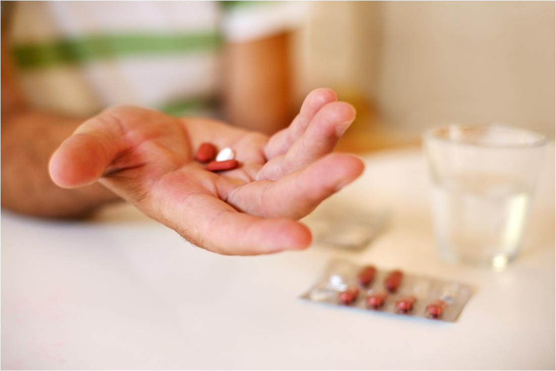 person holding pills and medicine