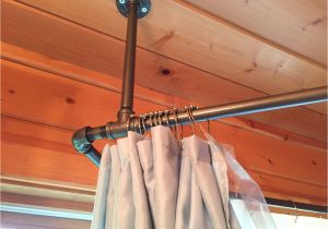 Sloped Ceiling Closet Rod Support Used Black Iron Piping to Create A Shower Curtain Rod that Surrounds